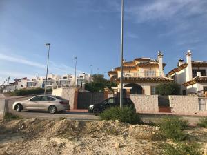 dos autos estacionados en un estacionamiento frente a las casas en Ric Rent, en Rojales