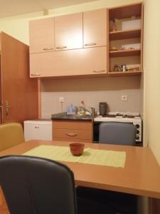 a kitchen with a wooden table with chairs and a sink at Apartman Zlatibor Dimitrije in Zlatibor