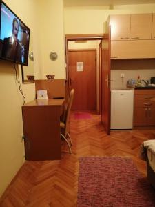 a living room with a table and a tv on the wall at Apartman Zlatibor Dimitrije in Zlatibor