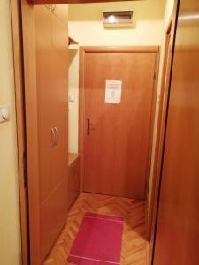 a hallway with a door and a pink rug at Apartman Zlatibor Dimitrije in Zlatibor