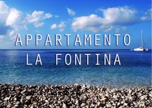 a rocky beach with a boat in the water at Appartamento La Fontina in Marciana Marina