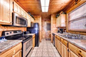 een keuken met houten kasten en een zwarte koelkast bij Black Bear Overlook in Pigeon Forge
