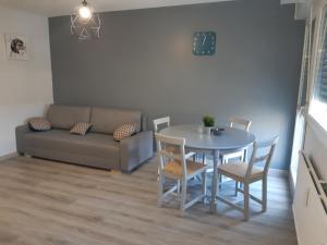 a living room with a table and chairs and a couch at Le Chabin in Metz