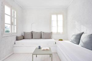 a white living room with a couch and a table at Cascade Holiday Resort in Poros