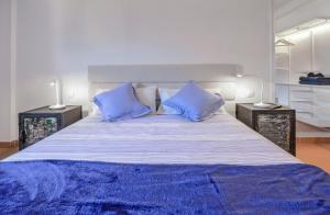 een slaapkamer met een groot bed met blauwe kussens bij vista oceano, confortevole, ampio, gran terrazza, Wi-Fi in Costa Calma
