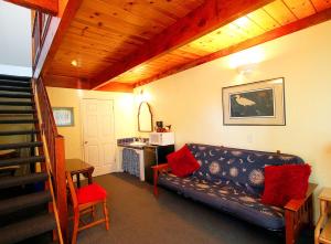 a living room with a couch and a staircase at Harbor Inn in Santa Cruz