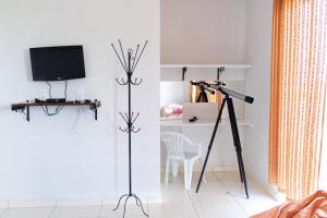 a room with a tripod and a television and a table at Pousada DDB in Resende Costa