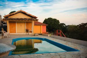 a house with a swimming pool and a playground at Pousada DDB in Resende Costa