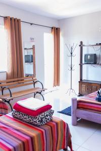 a room with two beds and a tv in it at Pousada DDB in Resende Costa