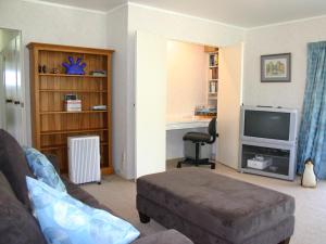 Una sala de estar con un sofá y un televisor. en Waihi Getaway - Waihi Beach Holiday Home, en Waihi Beach