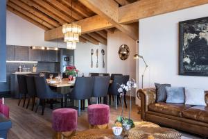 - un salon avec un canapé, une table et des chaises dans l'établissement Chalets du Koh-I Nor by Les Etincelles, à Val Thorens