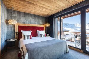 - une chambre avec un grand lit et une grande fenêtre dans l'établissement Chalets du Koh-I Nor by Les Etincelles, à Val Thorens