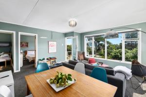 a living room with a table and a couch at Seaside House - Waikanae Beach Bach in Waikanae