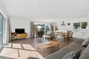 ein Wohnzimmer mit einem Sofa und einem Tisch in der Unterkunft The Waihi Beach House - Waihi Beach Holiday Home in Waihi Beach