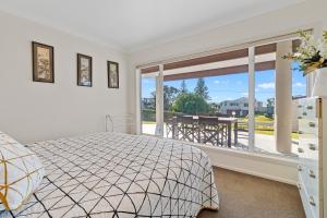 1 dormitorio con cama y ventana grande en Sea Shells By The Shaw - Waihi Beach Holiday Home, en Waihi Beach