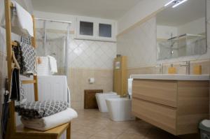 a bathroom with a sink and a toilet and a sink at Murdegus Maison - Vivi il tuo Sogno in Sardegna! in Tortolì +63 photos