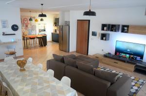 sala de estar con sofá, mesa y TV en Murdegus Maison - Vivi il tuo Sogno in Sardegna!, en Tortolì