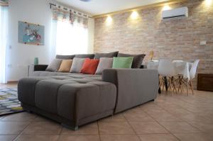 un soggiorno con divano grigio e cuscini colorati di Murdegus Maison - Vivi il tuo Sogno in Sardegna! a Tortolì