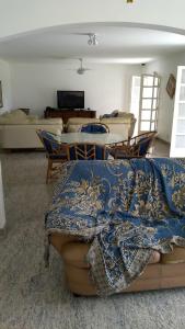 a living room with a couch with a blanket on it at Casa Eventos e Temporada com 4 suites, piscina, churrasqueira, Wi-Fi, Ar Condicionado - Proximo Praia Mar Casado e Pernambuco - Guaruja - in Guarujá