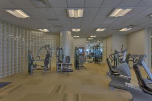 een fitnessruimte met loopbanden en machines in een kamer bij Escapes to the Shores in Orange Beach