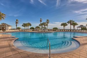 a large swimming pool with palm trees in the background at The Beach Club Resort and Spa III in Gulf Shores