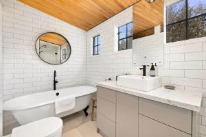 a bathroom with a tub and two sinks and a mirror at Wanaka Stone Cottage - Wanaka Holiday Home in Wanaka +19 photos