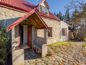 an old stone house with a red roof at Wanaka Stone Cottage - Wanaka Holiday Home in Wanaka