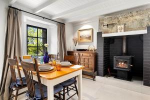 a dining room with a table and a fireplace at Wanaka Stone Cottage - Wanaka Holiday Home in Wanaka