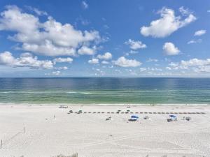 a beach with umbrellas and the ocean on a cloudy day at Summerchase 1 in Orange Beach