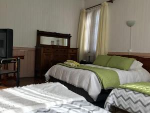a bedroom with two beds and a mirror at Hospedaje Mery in Cañete
