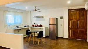 a kitchen with a refrigerator and a table and chairs at Casa Beu in Puerto Escondido