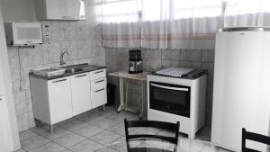 a small kitchen with a sink and a stove at Edifício Belio in Cascavel