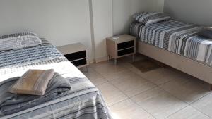 two beds sitting next to each other in a room at Edifício Belio in Cascavel