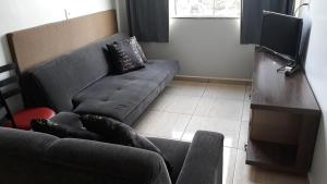 a living room with a couch and a television at Edifício Belio in Cascavel +6 photos