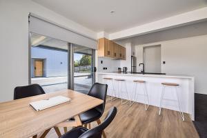 a kitchen and dining room with a wooden table and chairs at Southern Apartments Launceston in Launceston