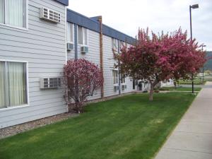 a building with a grass yard next to a house at Aero Inn in Kalispell