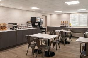 a restaurant with tables and chairs and a counter at Park Inn by Radisson, Calgary Airport North, AB in Calgary