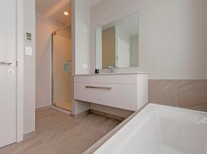 ein Badezimmer mit einem weißen Waschbecken und einem Spiegel in der Unterkunft Tattletails Rest - Whitianga Holiday House in Whitianga + 19 Fotos