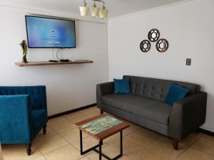 Il comprend un salon doté d'un canapé et d'une télévision à écran plat. dans l'établissement Casa Ohiggins, à La Calera
