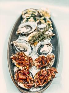 a plate of oysters on a plate with rosemary at ibis Styles Broken Hill in Broken Hill
