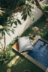 a garden with two chairs and a swimming pool at The Vira Bali Boutique Hotel & Suite in Kuta
