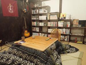 uma mesa numa cama num quarto com uma guitarra em Kominka Guesthouse Hagi Akatsukiya em Hagi