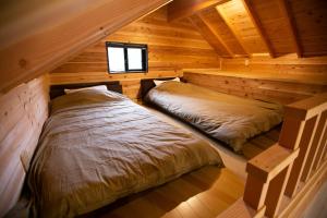 a bedroom with two beds in a log cabin at SHIOYA SPA in Minakami