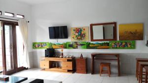 uma sala de estar com uma televisão na parede em Villa Dencarik em Lovina