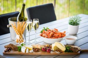 a table with a plate of seafood and glasses of champagne at Oleander Holiday Home - Airlie Beach in Airlie Beach