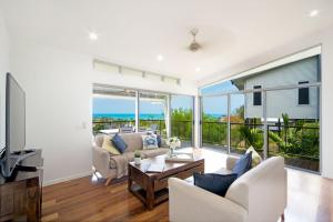 a living room with a view of the ocean at Oleander Holiday Home - Airlie Beach in Airlie Beach