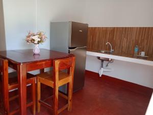 a small kitchen with a table and a refrigerator at Tongatok Cliff Resort in Mambajao