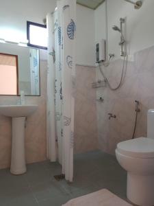 a bathroom with a shower and a toilet and a sink at Tongatok Cliff Resort in Mambajao