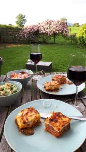 a table with two plates of food and a glass of wine at 40 Winks in Otorohanga