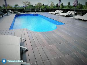 a large swimming pool with chairs on a wooden deck at Desa Selatan Resort Pengerang in Pengerang